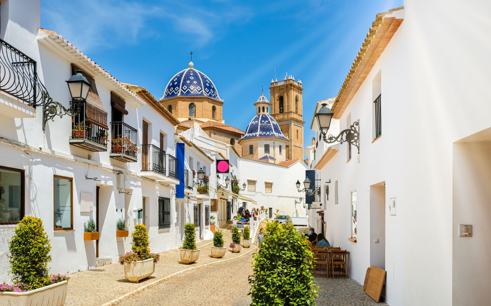 Street of Altea old town in Spain. Beautiful village with white houses and blue domed church Our Lady of Solace. Popular Spanish tourist destination, Costa Blanca region