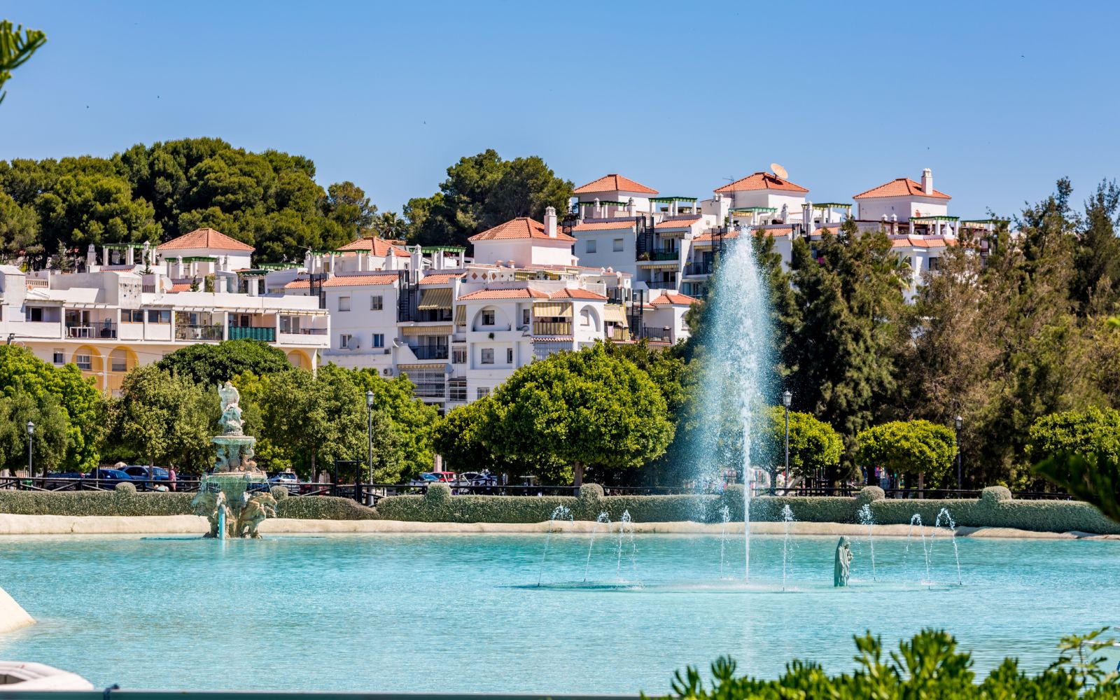 Sprinkling fountain in the park, sunny spring view from 