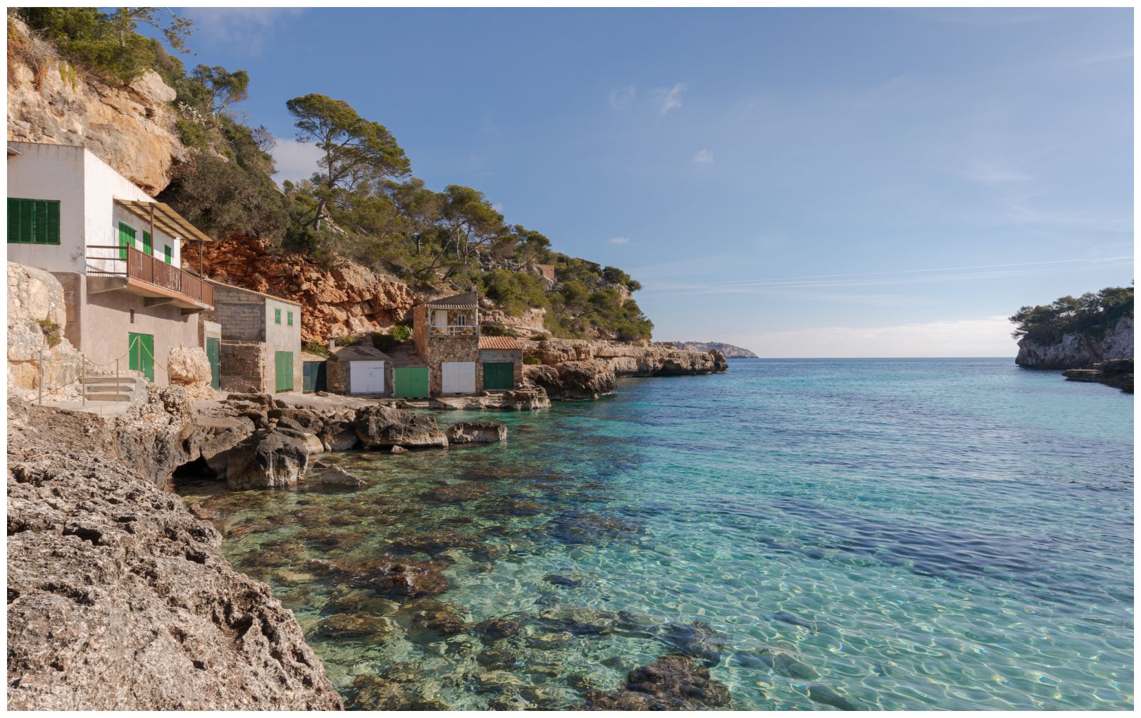 Cala Llombards (Mallorca, Balearic Islands, Spain). A cove with crystal clear turquoise waters, houses with jetties and a fine sandy beach.